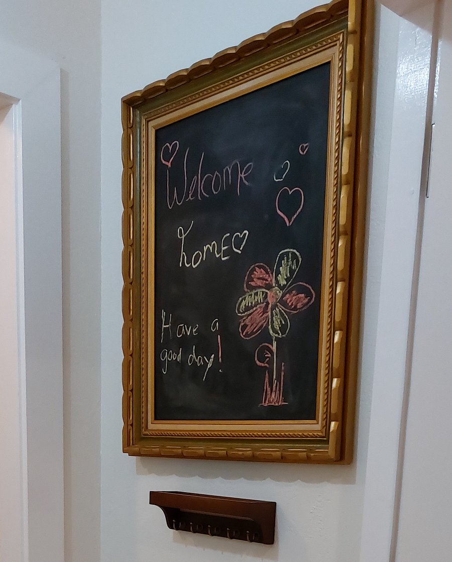 Entry "Welcome Home" chalkboard and key holder. On the other side there is a "Storage Closet" and coat rack.