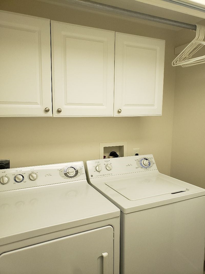 Indoor laundry room!!! Hanging rod for drying clothes. A cupboard space on right. Iron and full size (and smaller table top size) ironing board.