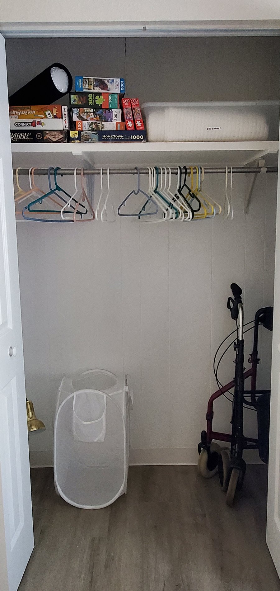 Guest Bedroom closet stores laundry basket and puzzles and games.