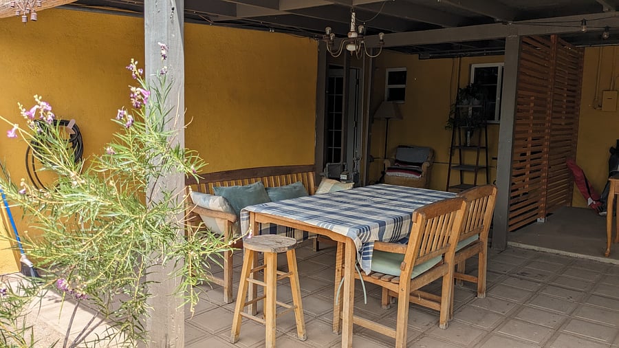 Teak dining table on the covered patio outside the studio