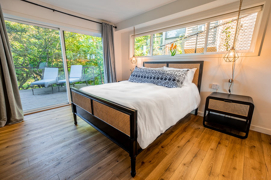 Guest room with sliding doors to exterior deck, tv, and queen size bed.