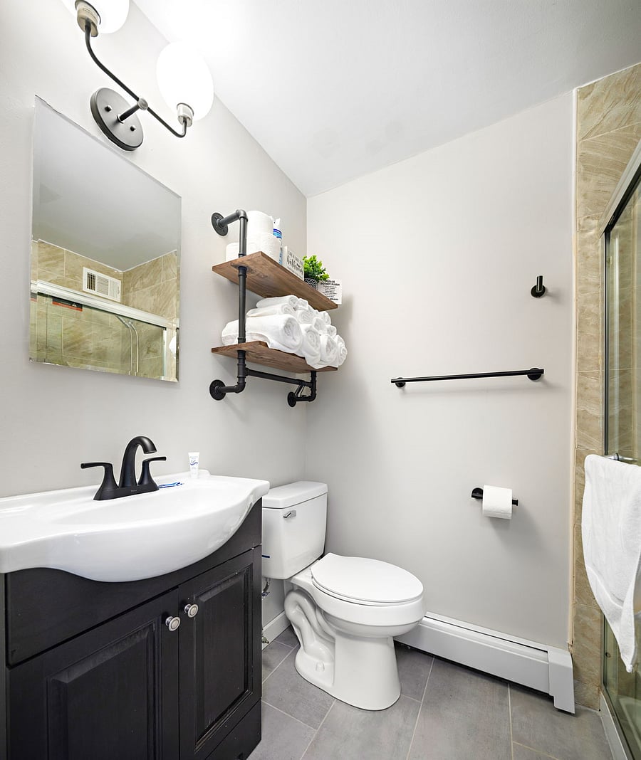 Bathroom with toiletries, mounted hairdryer, and towels/washcloths