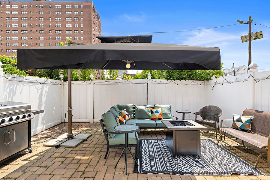 Fabulous patio with umbrella and seating area, grill, and fire table