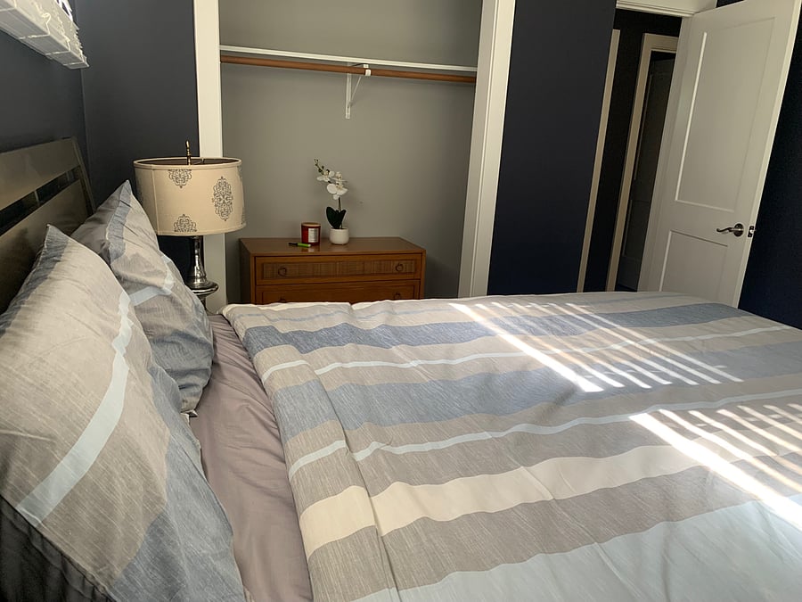 MBR located on the front side of the home with closet and dresser and queen bed.