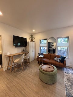 This angle of this particular set up gives you another look with this layout option of the versatile studio bedroom. It creates a natural flow between lounging, dining, and relaxing, while the windows bring in soft light that makes it all feel warm and inviting.