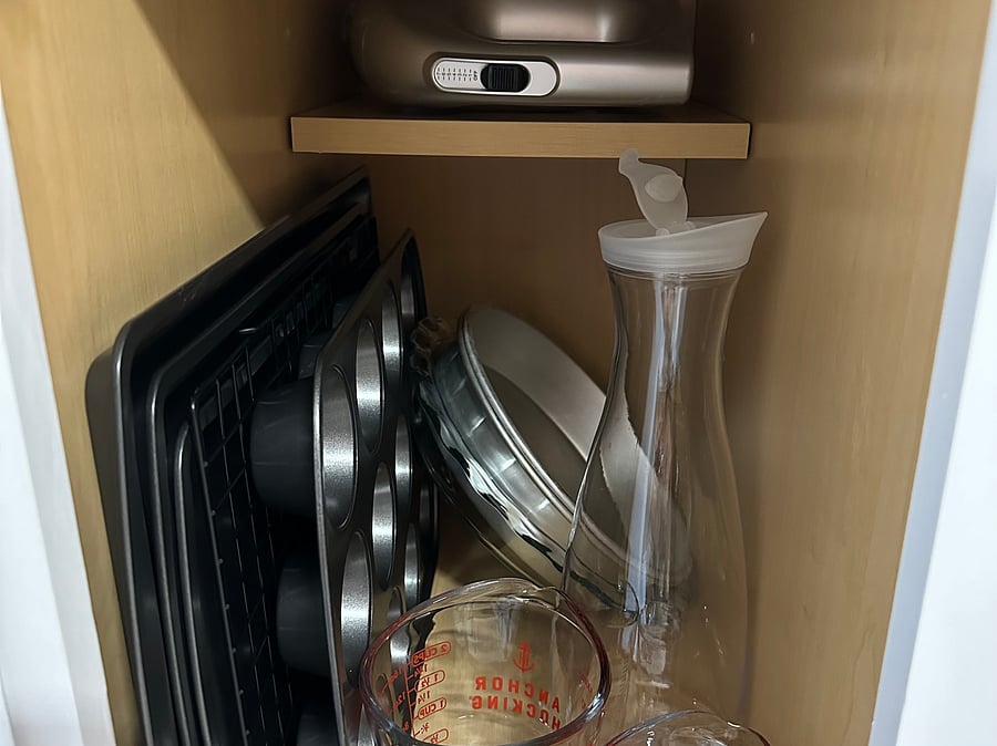 Various baking supplies, hand mixer is on the shelf