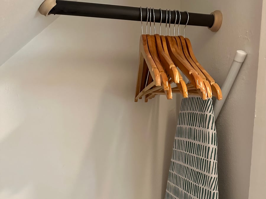 Full size ironing board (iron is in one of the baskets on the shelf) and hangers