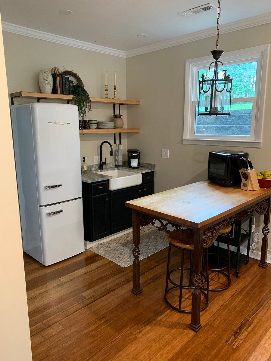 Butcher block chopping island in kitchenette. Microwave and knife set on top.