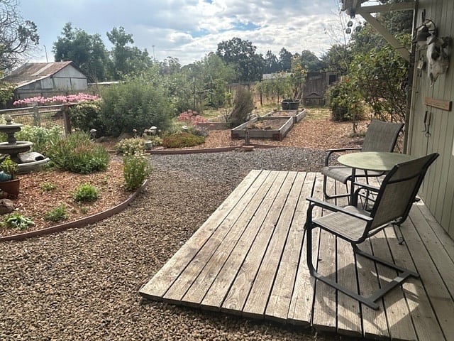 View from back door and greenhouse window box over kitchen sink. Private yard with deck for sitting area.