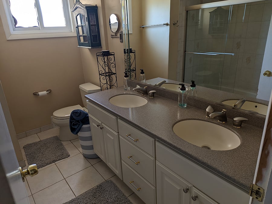 Full bath with double vanity and shower / tub with glass shower door