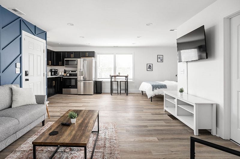 Open-concept living space with modern furnishings, a sleek kitchen, and bright natural lighting.
