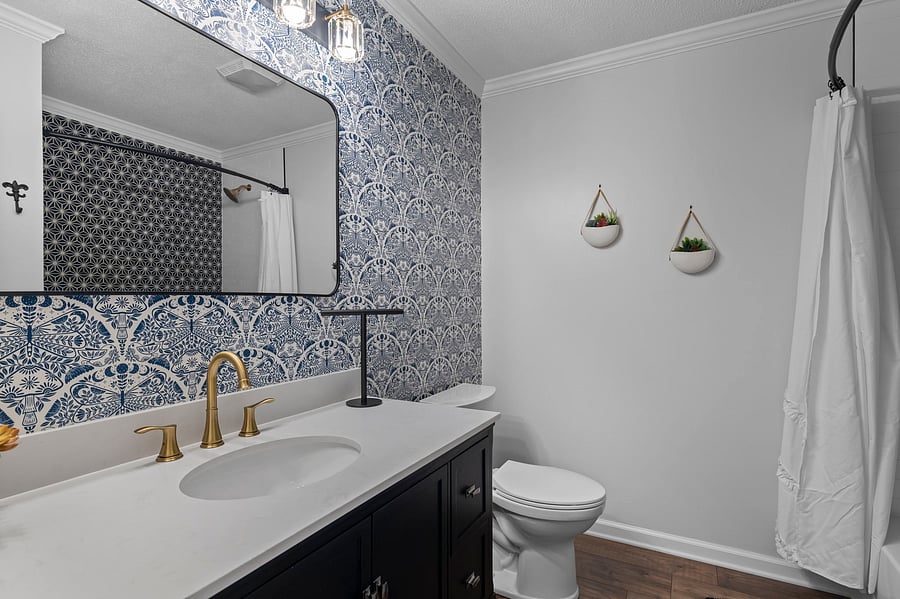 Upstairs full bath off the hallway with shower/tub combo, large vanity and toilet.