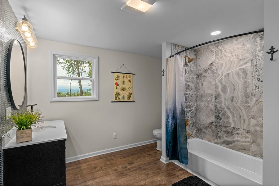 Downstairs master bath with tub/shower combo and large vanity and toilet.
