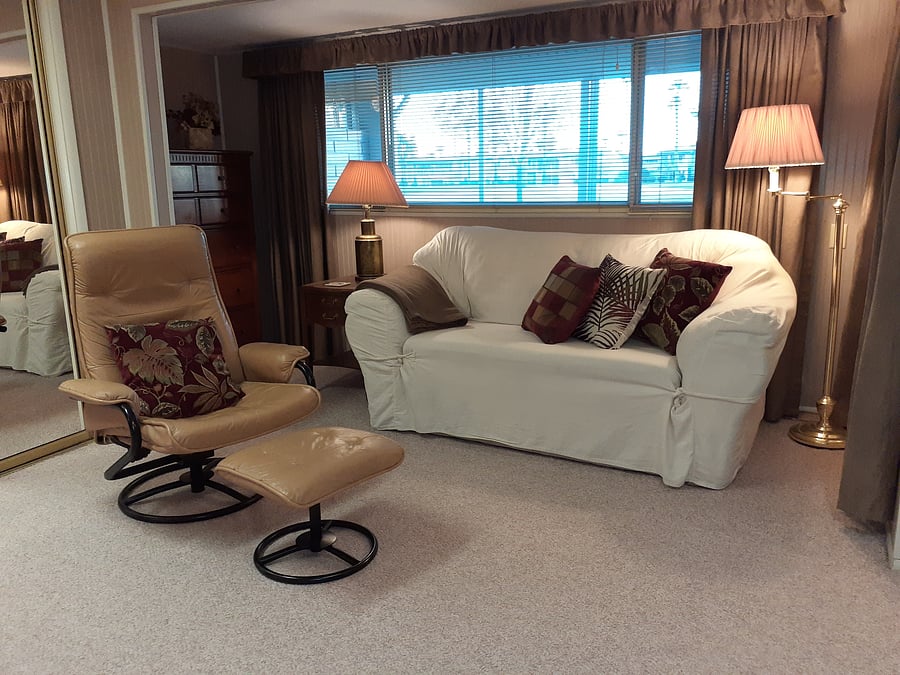 Living area has a 10 ft. horizonal window that looks out over the patio and yard to the golf course. The love-seat will be covered with a freshly washed cover so you can relax on it.