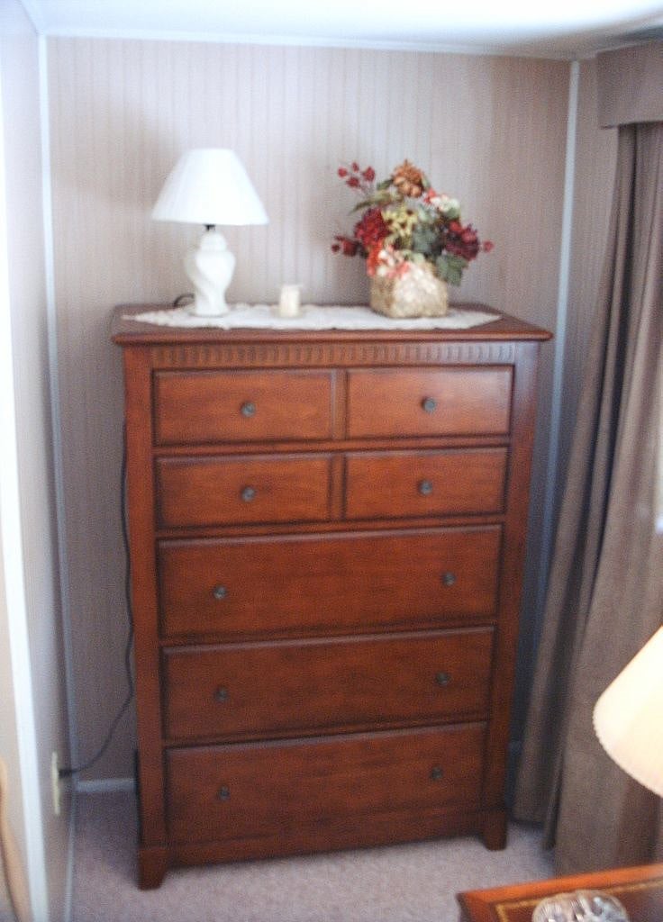 Tall chest-of-drawers for storage.