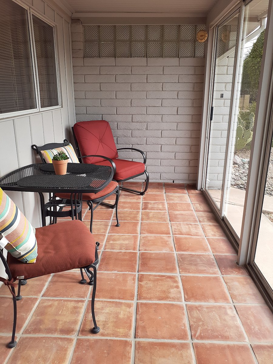 Outdoor patio-porch, shady in the summer, can open to the outdoors, or close to be a sunroom in winter, with wrought iron table & chairs, and a cushy patio chair that is a rocker.