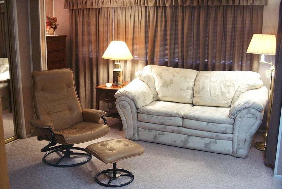 The comfy loveseat to relax on; pictured without the cover with the window drapes closed.