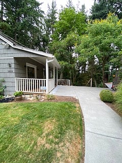 side with sitting porch and front door and patio.