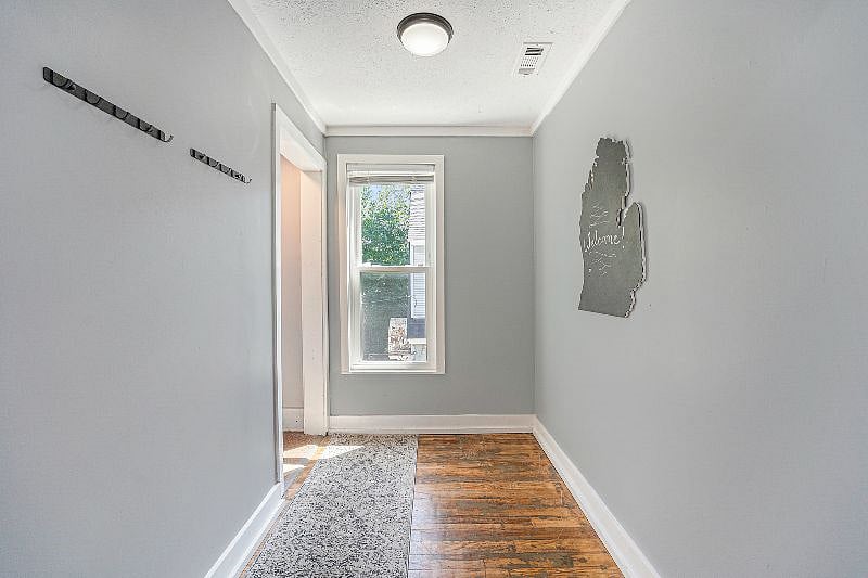 Entryway to the unit. There are coat hangers on the wall.