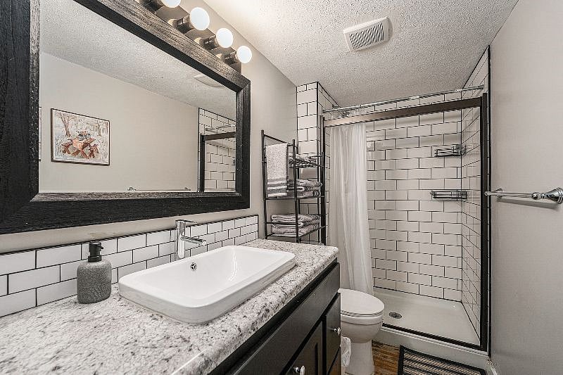 Newly updated bathroom has beautiful subway tile in the shower. The shower also has since had a glass shower door installed.