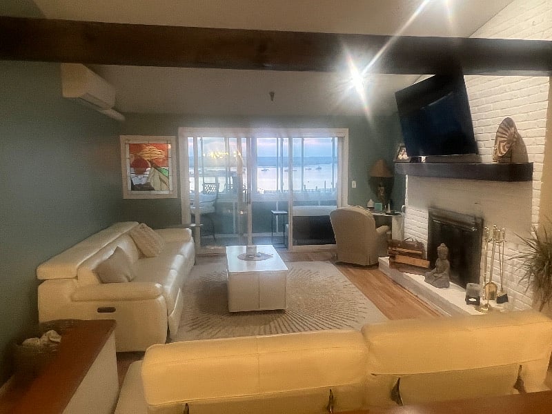 Living room with fireplace and step out onto the third-floor porch that overlooks the marina and harbor