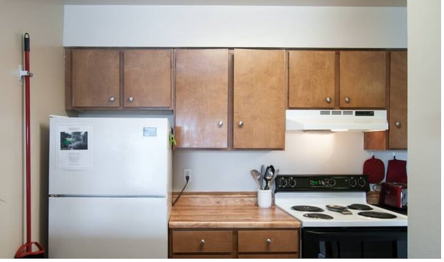 Full-size refrigerator and bar with stools.