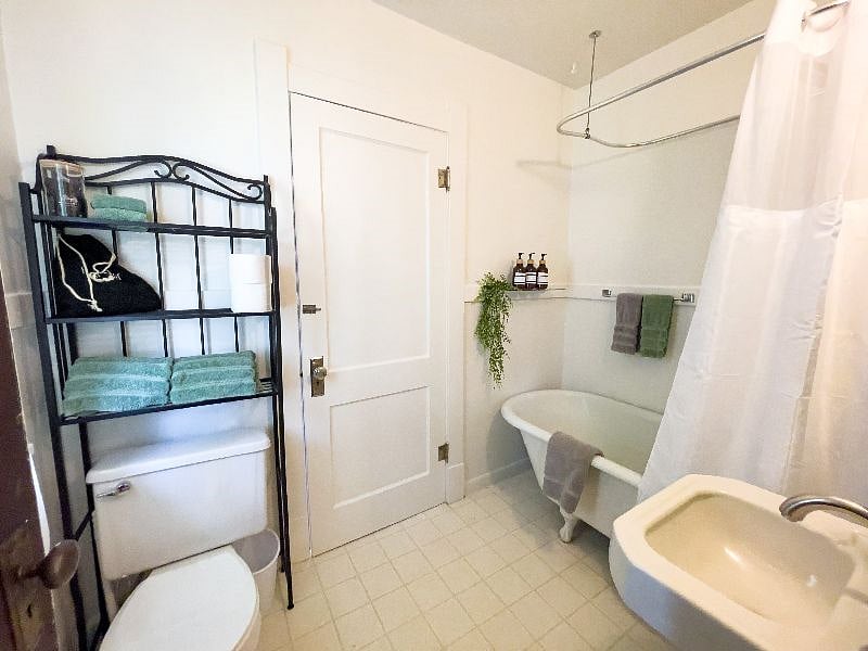 Bathroom with clawfoot tub, linens, and essentials. 