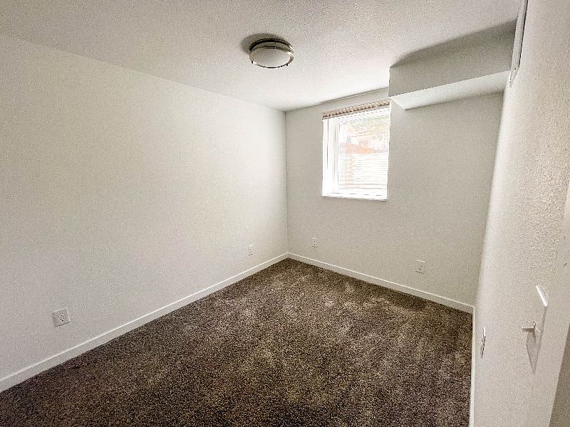 Smaller unfinished basement bedroom.