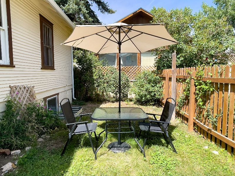 The courtyard includes a table, chairs, and umbrella, perfect during Laramie summers. 