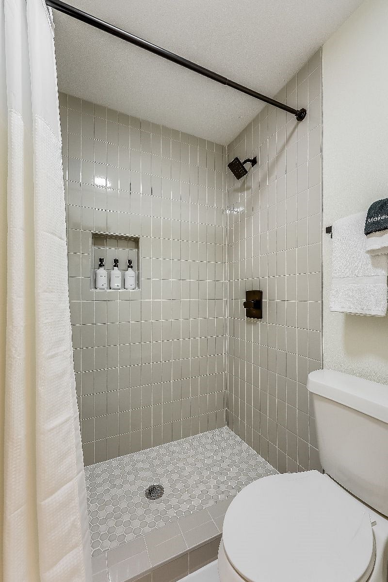 Primary en-suite walk-in shower complete with shampoo, conditioner, and body wash, provided for your convenience.