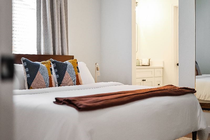 Primary Bedroom with an en-suite walk-in shower, blackout curtains and blinds.