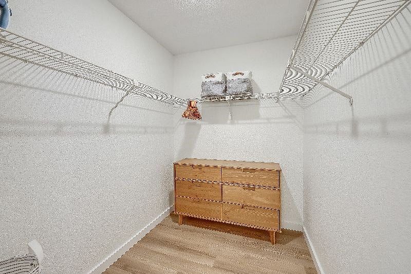 Walk in closet in primary bedroom - Plenty of closet and drawer space for the clothes you bring with you and the clothes you purchase at The Domain outdoor mall (5 Min). Also comes with a hamper, ironing board, and iron.