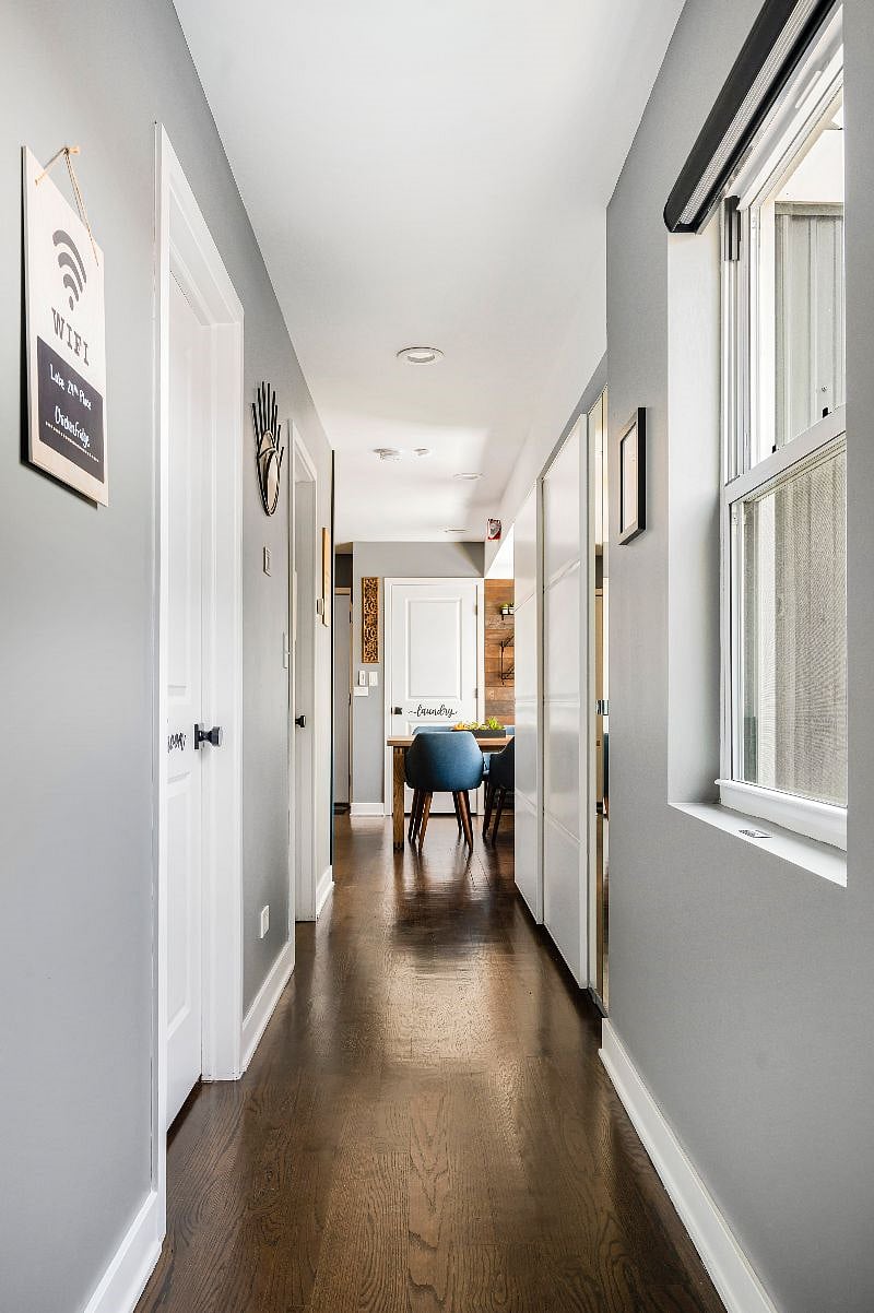 A view down the hallway from the back entry - bedroom & bathroom doors are on the left. This unit has a lot of windows and plenty of natural light! (+smart blackout shades)