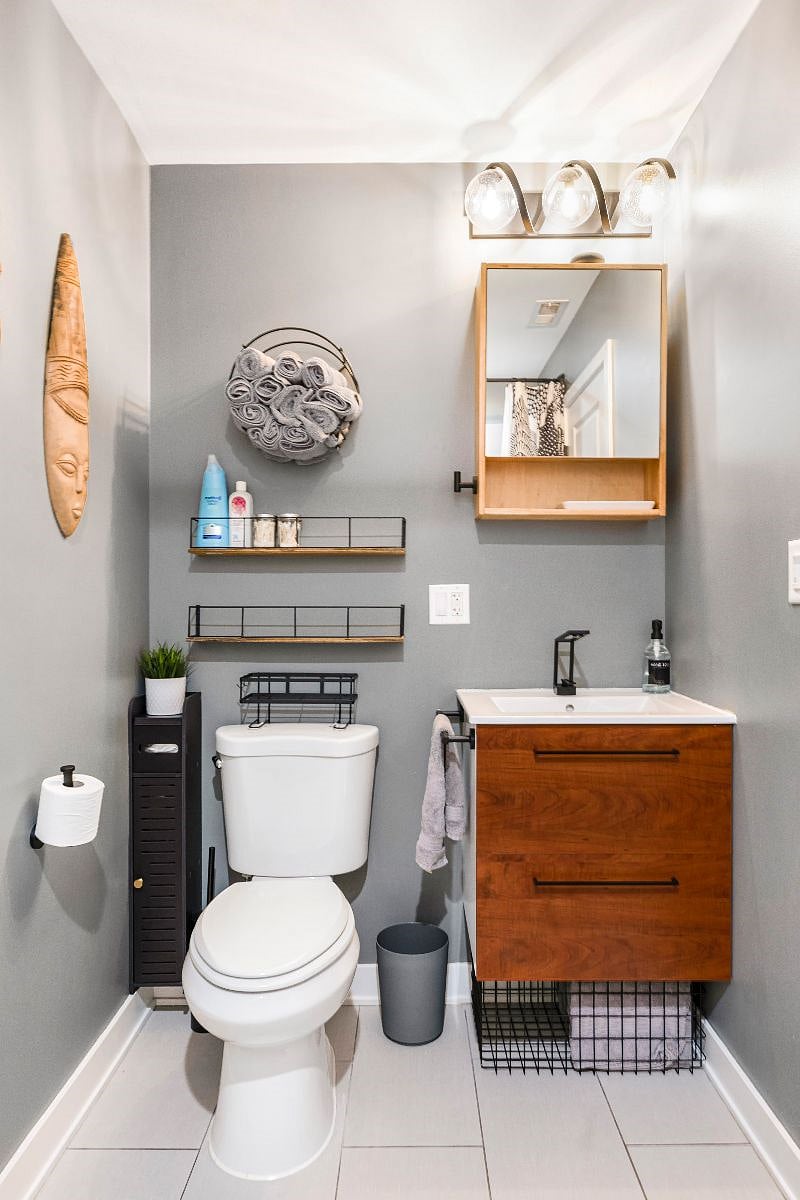 Fresh, clean, updated bathroom with plenty of fluffy towels and soap. Custom lighting and black fixtures. Tub/shower is on the opposite wall.