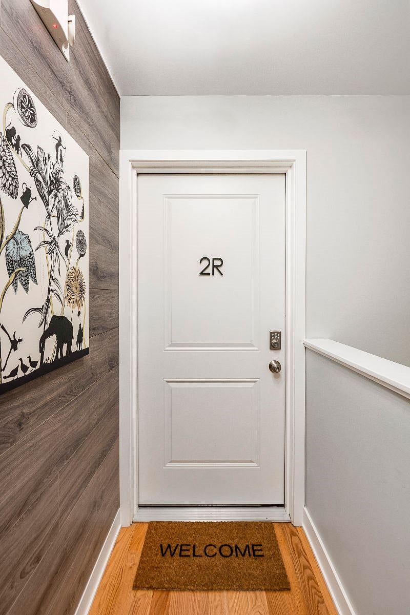 Interior unit entry door through the common shared hallway. This 2 story building was constructed new in 2020, providing a bright, fresh, clean feeling throughout!