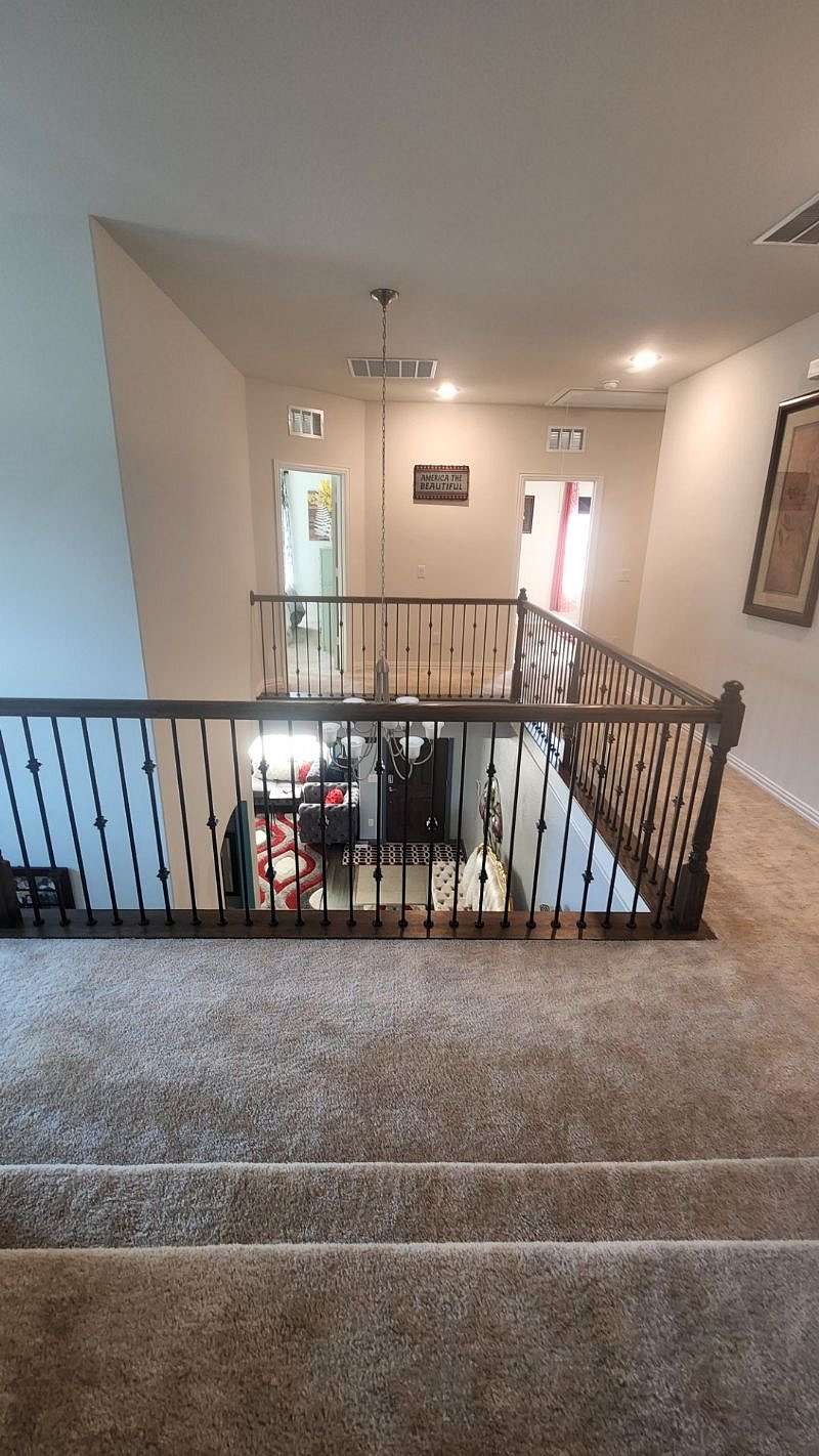 Upstairs banisters and hallway which leads to bedrooms and bathrooms.