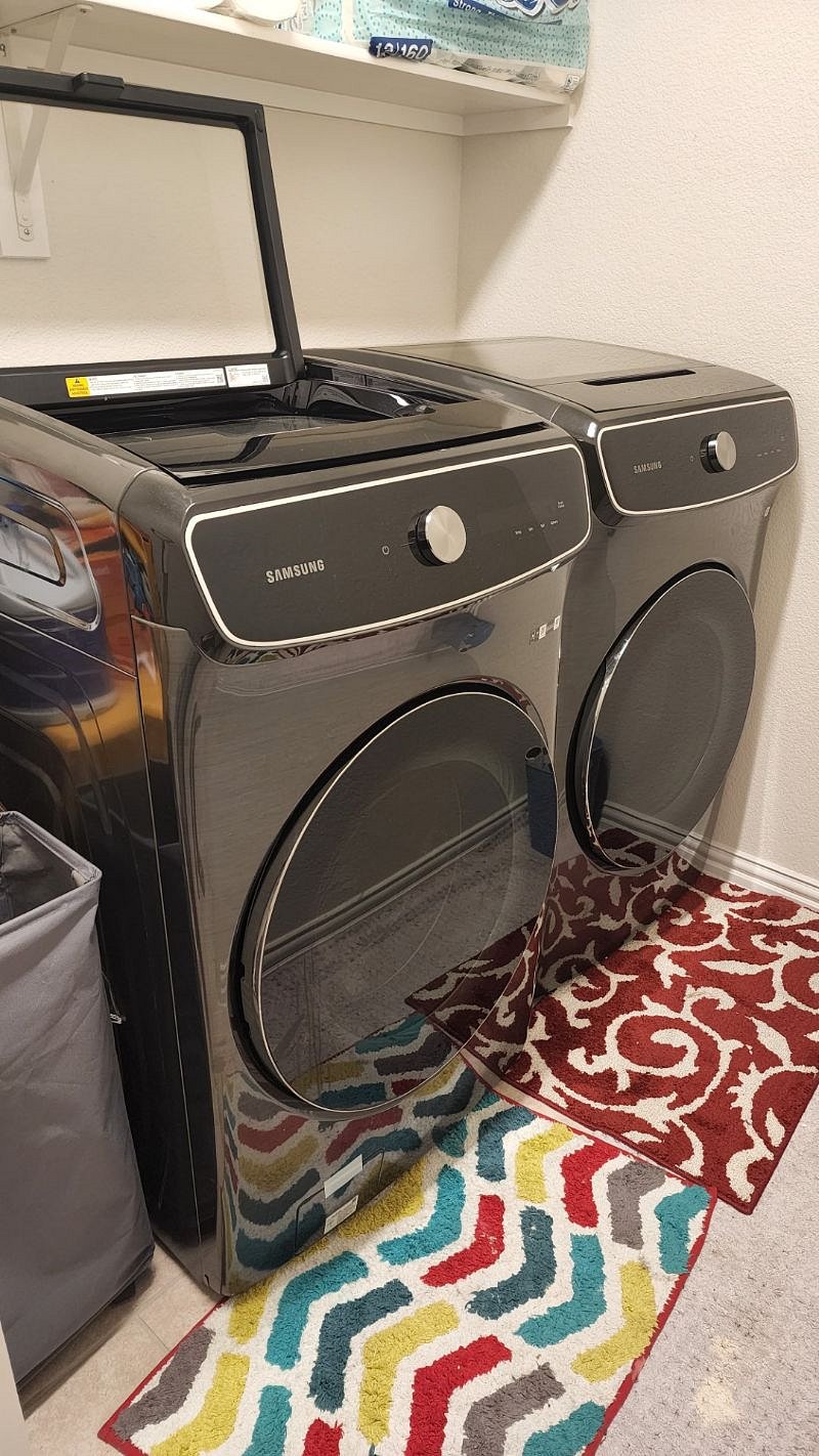 Laundry room with washer, dryer, broom, dust pan, and mop.