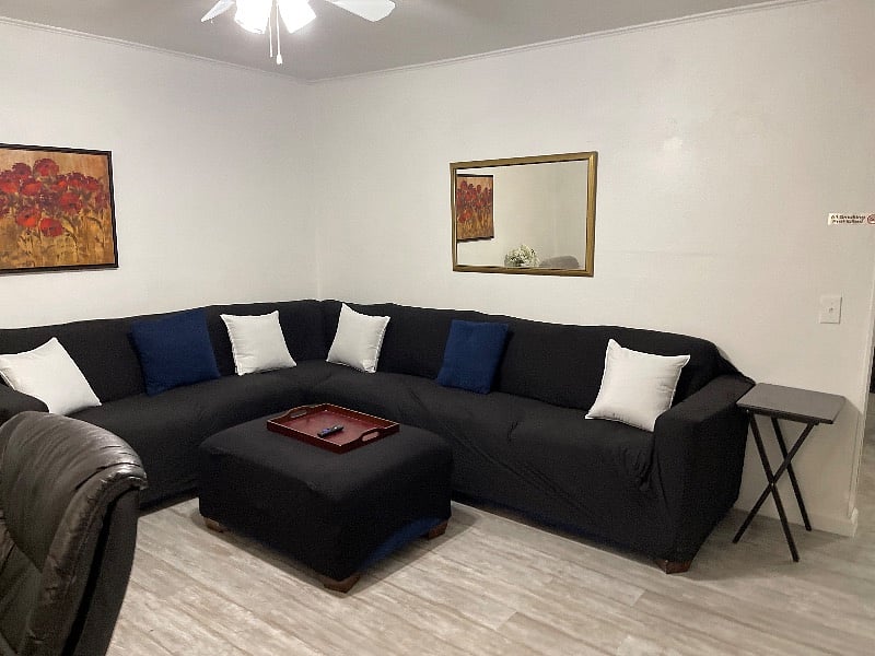 Living room with large sectional and smart TV and desk area