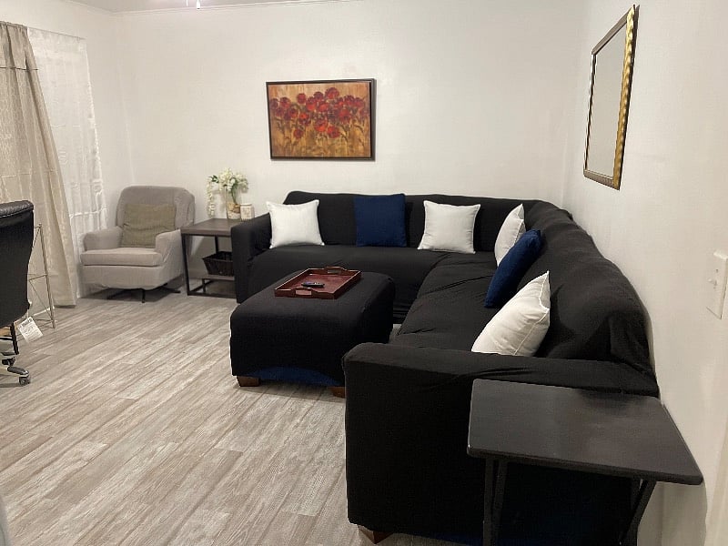 Living room with large sectional and smart TV and desk area