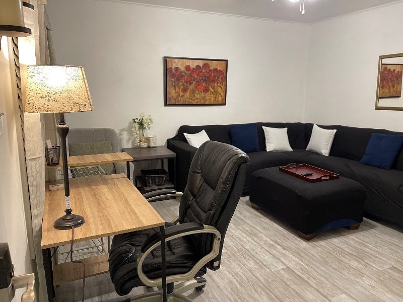 Living room with large sectional and smart TV and desk area