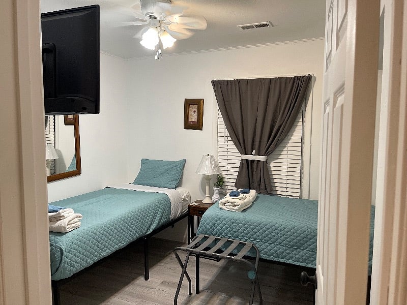 Bedroom number one with two twin XL beds smart TV, two luggage racks, two USB nightstands, and a large chest of drawers