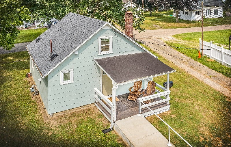 Rear porch with two Adirondack chairs.