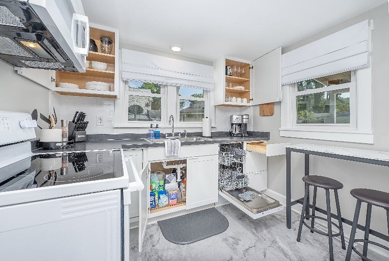 Fully stocked kitchen with dishwasher, stove/oven, microwave, dual coffee maker, toaster, mixer, blender, crock pot, pots and pans, baking sheets, and cutting boards.