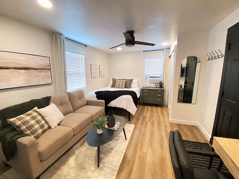 Comfortable environment with window AC unit, overhead fan, and multiple lighting options. 