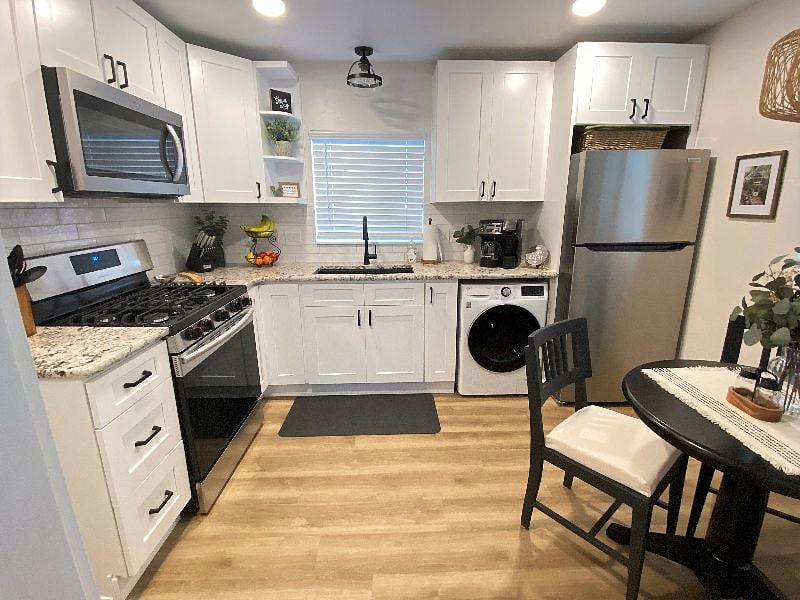 Brand new appliances including an all-in-one washer/dryer unit, full size refrigerator, and gas range. 