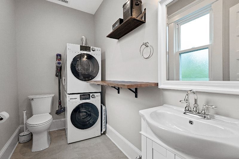 Located on the second floor, this shared half bathroom features a vanity, toilet, and a convenient in-unit washer and dryer.