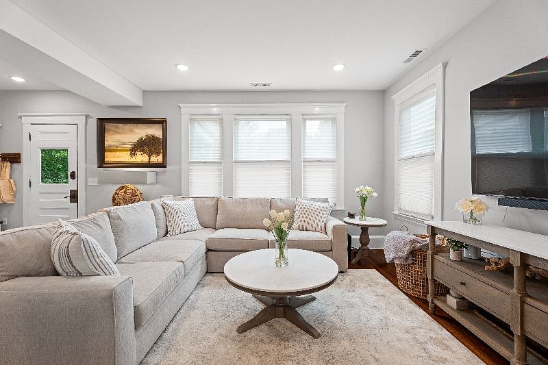 Relax and unwind in our shared living room, featuring a spacious sectional sofa, a coffee table, and a large wall-mounted TV for your entertainment.
