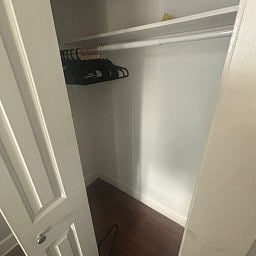 Closet featuring built-in shelving, a hanging rod, and hangers.