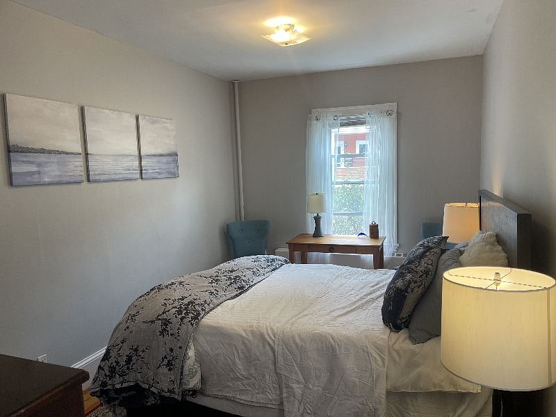 large downstairs bedroom with desk and dresser, comfortable temperpedic-style mattress