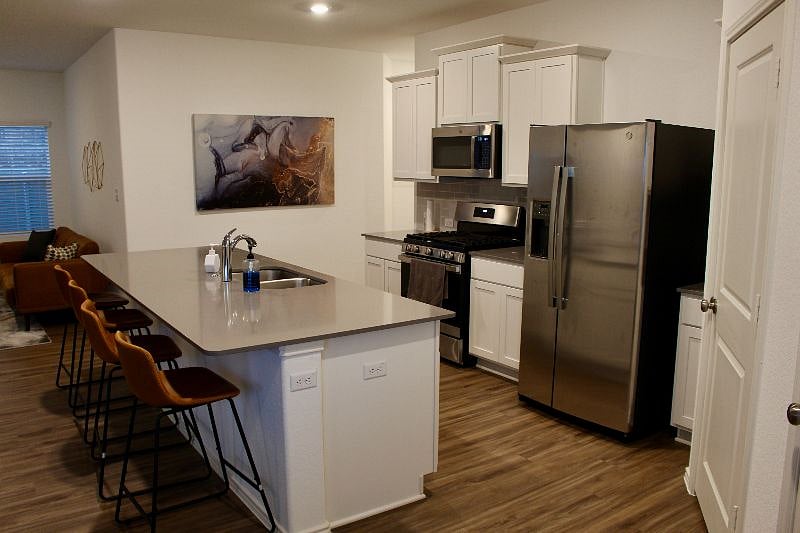 Kitchen comes with Microwave, Stove, Refrigerator, dishwasher, and starter supplies.